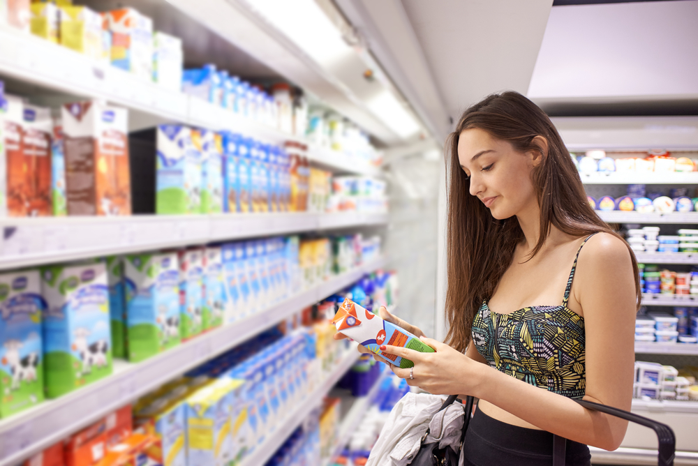young woman shopping for fruits and vegetables in produce department of a grocery store supermarket young woman shopping for fruits and vegetables in produce department of a grocery store supermarket